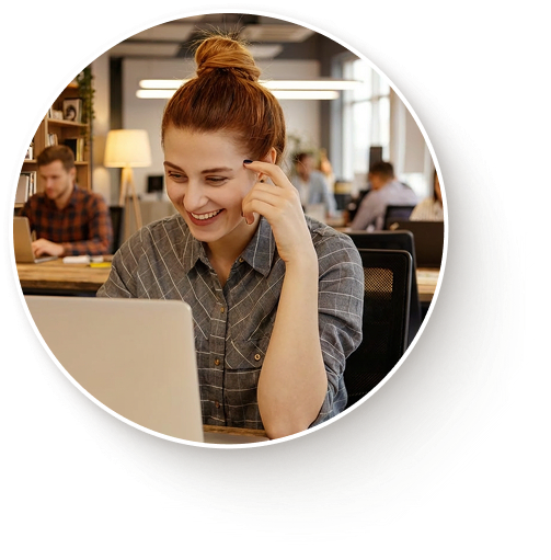photo d'une femme souriant devant son ordinateur au travail